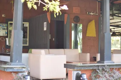 a room with chairs and a table in a building at Ibni Springs in Madikeri