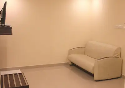 a white chair in a corner of a room at Aura Residency in Trichūr