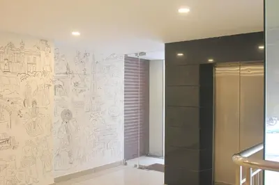 a bathroom with a drawing on the wall at Aura Residency in Trichūr