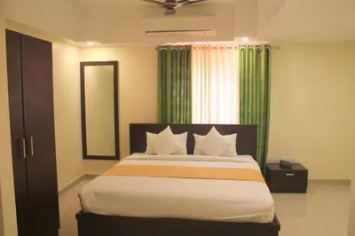 a bedroom with a large bed and a window at Aura Residency in Trichūr