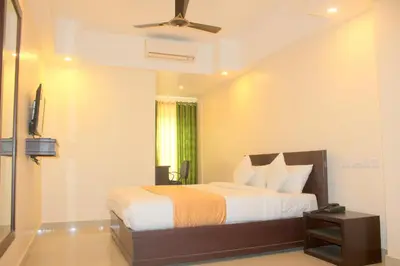 a bedroom with a bed and a ceiling fan at Aura Residency in Trichūr