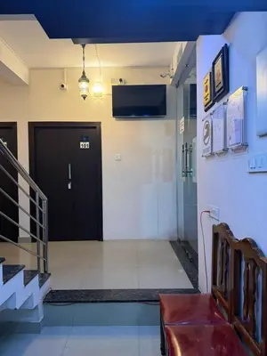 a lobby with a black door and a red bench at La Mer Inn in Kozhikode