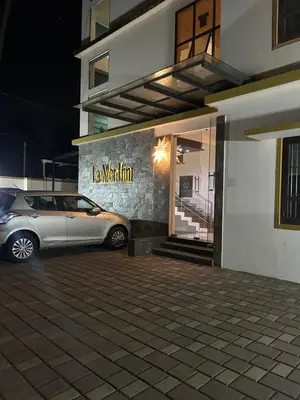 a car parked in front of a building at night at La Mer Inn in Kozhikode