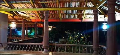 a porch with a wooden roof with lights on it at Wayal Wayanad Farm Resort in Panamaram