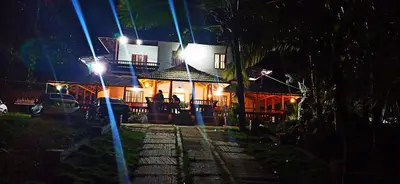 a house with a street light in front of it at night at Wayal Wayanad Farm Resort in Panamaram