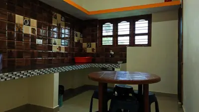 a kitchen with a wooden table in a room at Coorg peacock feathers home stay in Kushālnagar