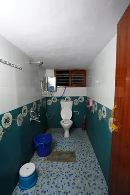 a small bathroom with a toilet in a room at Coorg peacock feathers home stay in Kushālnagar