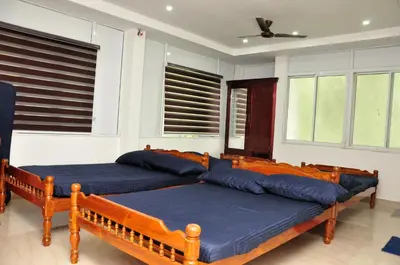 two beds in a room with windows at Fresh Up In Guruvayur Krishnendhu Residency in Guruvāyūr