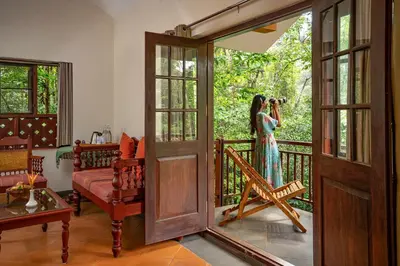 a woman taking a picture of a woman on a balcony at Vythiri Mist Resort in Vythiri