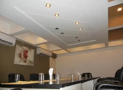 a conference room with a table and chairs and a ceiling at Sayoojyam Residency in Palakkad