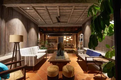 a living room with a couch and chairs and a table at Periyar River Lodge in Thattakād