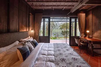 a bedroom with a large bed and a desk at Periyar River Lodge in Thattakād