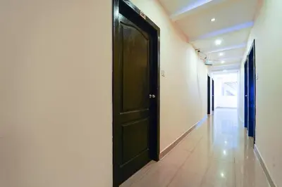 an empty hallway with a black door in a building at Zion Plaza in Nedumbassery