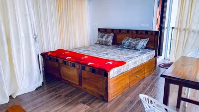 a bedroom with a wooden bed with red sheets at CHILLAX Resorts Palakkayam THATTU in Paithalmala