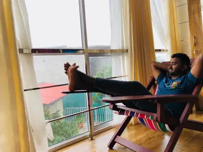 a man sitting in a chair looking out of a window at CHILLAX Resorts Palakkayam THATTU in Paithalmala