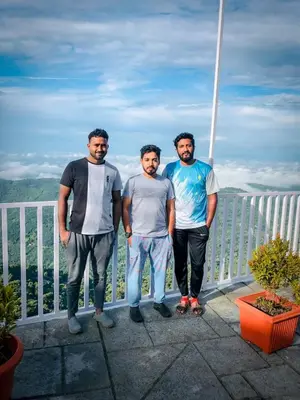 three men standing next to each other on a balcony at CHILLAX Resorts Palakkayam THATTU in Paithalmala