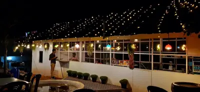 a man standing in front of a bar with lights at CHILLAX Resorts Palakkayam THATTU in Paithalmala