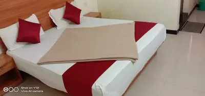 a bed with red and white sheets and pillows at Red Star Holidays in Munnar