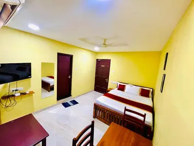 a bedroom with a bed and a desk and a tv at MADAPARAMBIL RESIDENCY in Alwaye