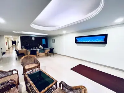 a waiting room with chairs and a tv on the wall at MADAPARAMBIL RESIDENCY in Alwaye