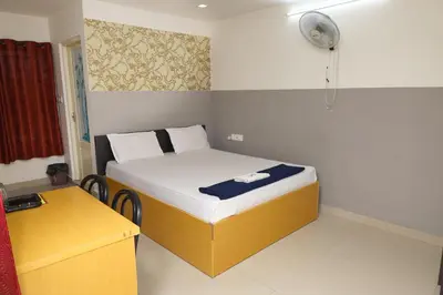 a small bedroom with a bed and a fan at GREEN LINE RESIDENCY in Nedumbassery
