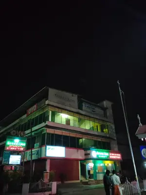 a building at night with people standing in front of it at GREEN LINE RESIDENCY in Nedumbassery