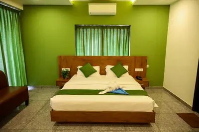 a bedroom with a large bed with green walls at Hillfort Inn in Sultan Bathery