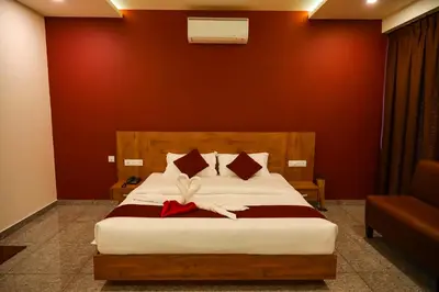 a bedroom with a bed with a red wall at Hillfort Inn in Sultan Bathery