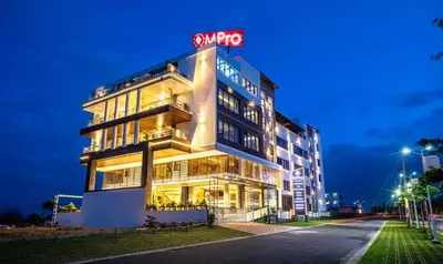a building with a neon sign on top of it at Hotel M Pro Palace Mysore - 12 Minutes to Mysore Palace in Mysore