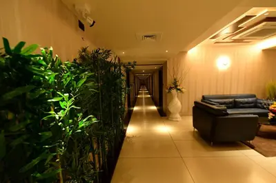 a hallway with a couch and some plants at Hotel M Pro Palace Mysore - 12 Minutes to Mysore Palace in Mysore