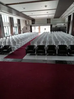 an empty room with white chairs and a red carpet at Hotel M Pro Palace Mysore - 12 Minutes to Mysore Palace in Mysore