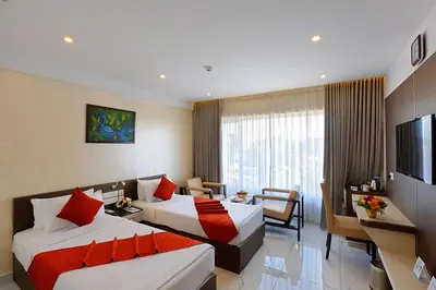 a hotel room with two beds and a television at Renai Sreekrishna in Guruvāyūr