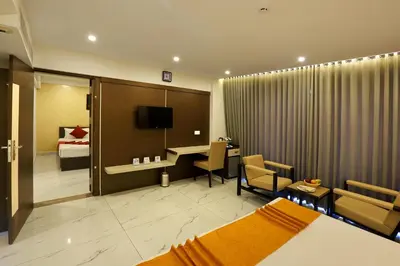 a hotel room with a bed and a desk in it at Renai Sreekrishna in Guruvāyūr