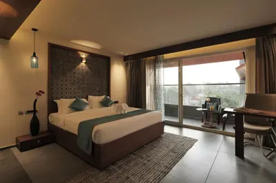a bedroom with a bed and a desk and a window at GRANDE IRIS in Sultan Bathery