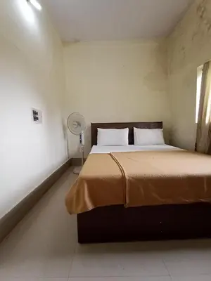 a bedroom with a bed with a fan and a window at KABINI FARM STAY in Antarasante