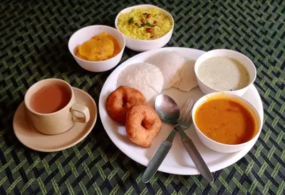 a plate of food with two donuts and two cups of coffee at KABINI FARM STAY in Antarasante