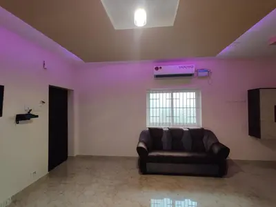 a living room with a couch and a pink wall at Sivamurugan residency in Bhavāni