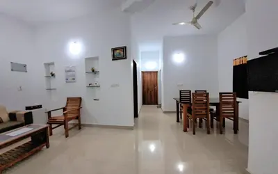 a living room with a table and chairs at Pearl Inn in Kottakkal