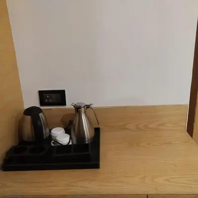 a tray with a tea kettle and cups on a wooden floor at PPH Living Railotel Coimbatore in Coimbatore