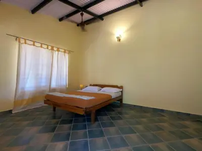 a bedroom with a bed in a room with a window at Runnel View in Masinagudi