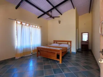 a bedroom with a bed and a large window at Runnel View in Masinagudi