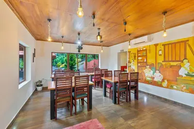 a dining room with wooden tables and chairs at Serene Valley Resort Wayanad in Mananthavady