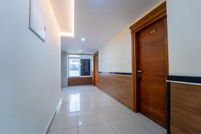 a hallway with a wooden door and a tile floor at Treebo Sree Varshavilas Regency, 500 Mtrs From Guruvayoor Temple in Guruvāyūr