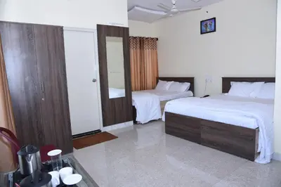 a hotel room with two beds and a mirror at Yashas Paradise in Nanjangūd