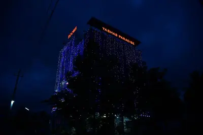 a christmas tree with blue lights in front of a building at Yashas Paradise in Nanjangūd