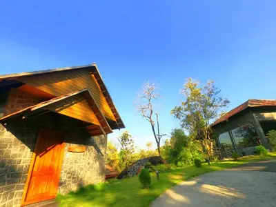 a building with a wooden door on the side of it at The Wild Trails Clarks Exotica , Munnar in Munnar