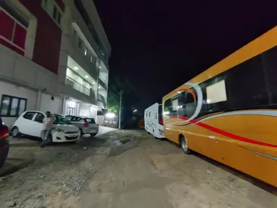 a yellow bus parked next to a building at night at The Grand Inn in Kanjikode