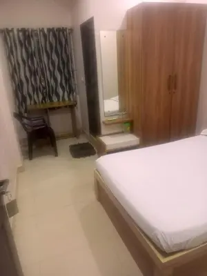 a bedroom with a bed and a chair and a mirror at The Grand Inn in Kanjikode