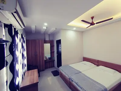 a bedroom with a bed and a ceiling fan at The Grand Inn in Kanjikode