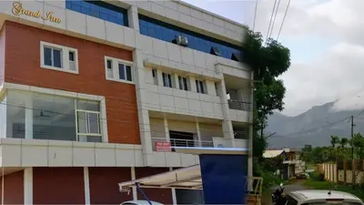 a tall building with a red and white at The Grand Inn in Kanjikode